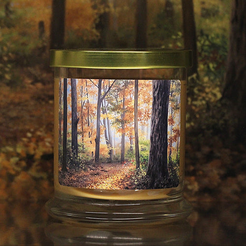 Close up view of a leaves scented candle with original decorative artwork on the glass jar.