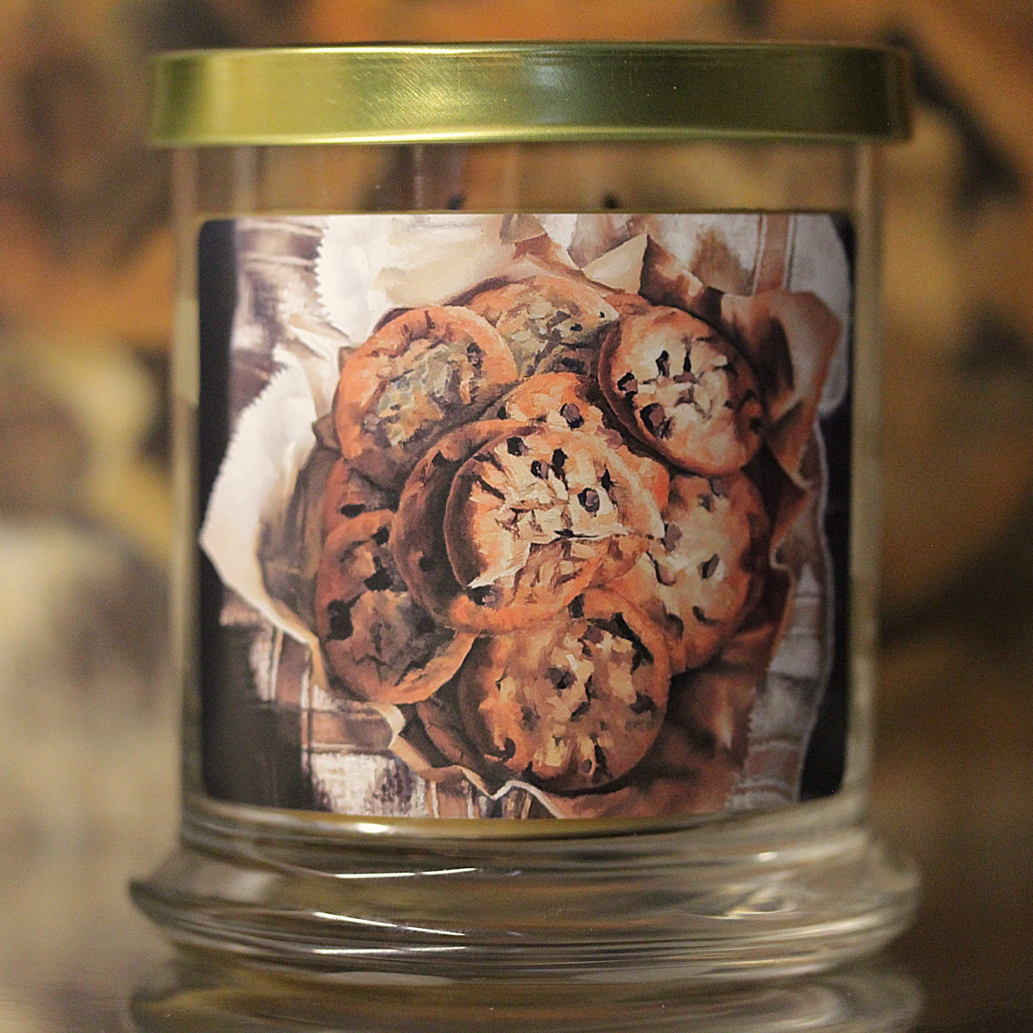 Close up view of unlit vanilla scented candle with original decorative artwork on the glass jar.