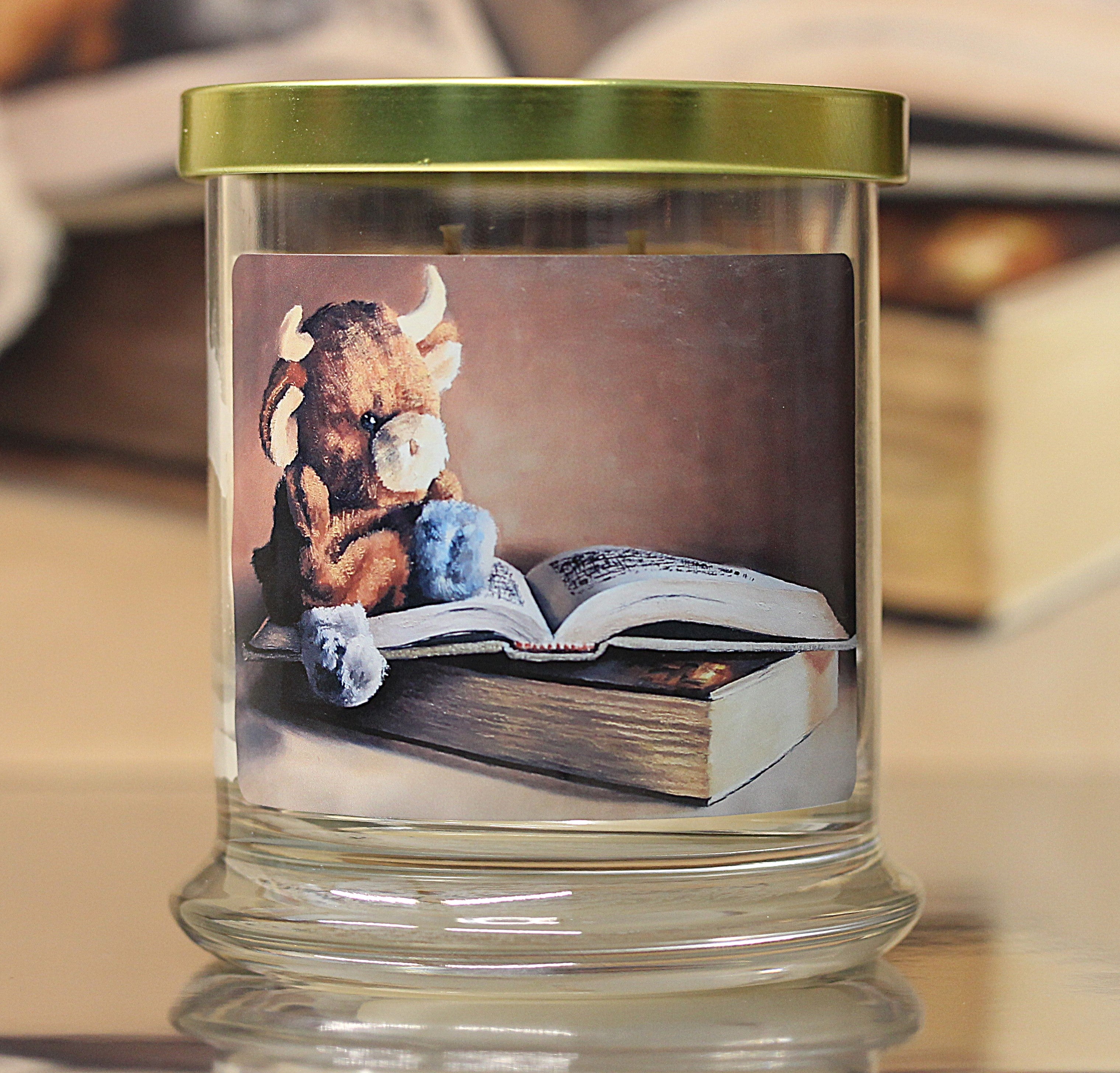 Close up view of an unlit cashmere scented candle with original cozy artwork on the glass jar.