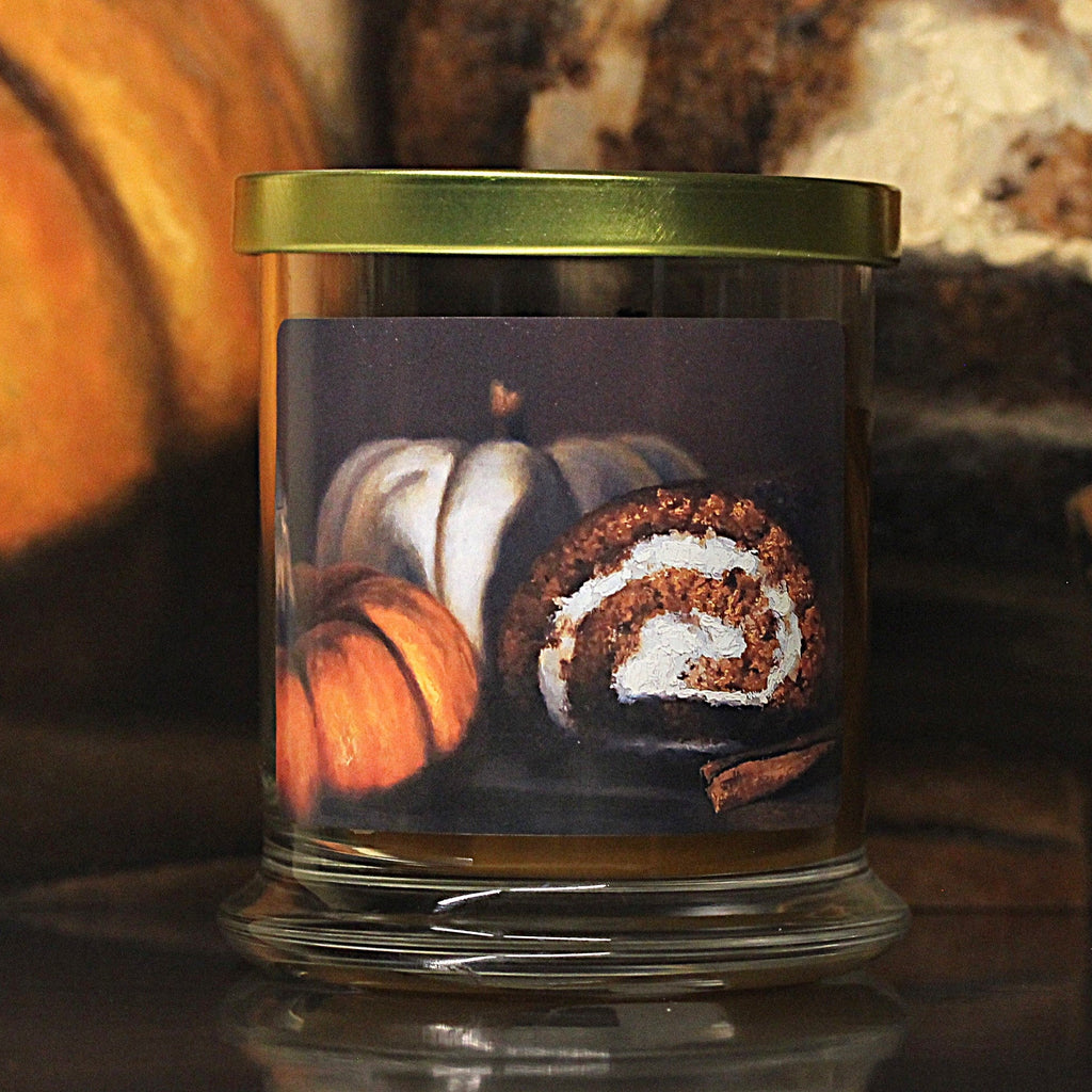 Close up view of a pumpkin scented candle with original decorative artwork on the glass jar.
